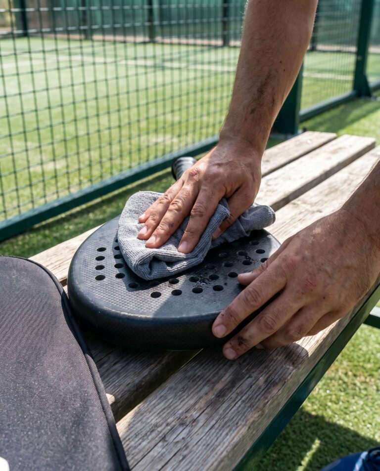 Nettoyage de la face d'une raquette de padel avec un chiffon