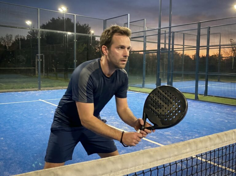 Joueur de padel au filet avec sa raquette
