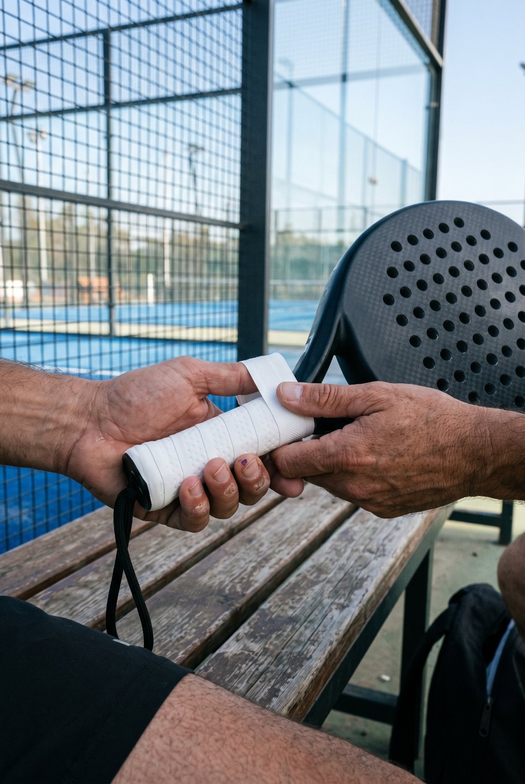 Pose d'un overgrip sur le manche d'une raquette de padel