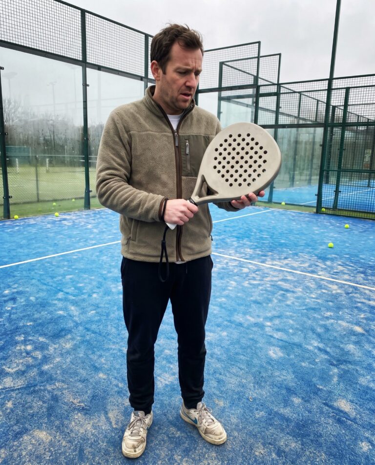 Débutant découvrant sa première raquette de padel sur un terrain