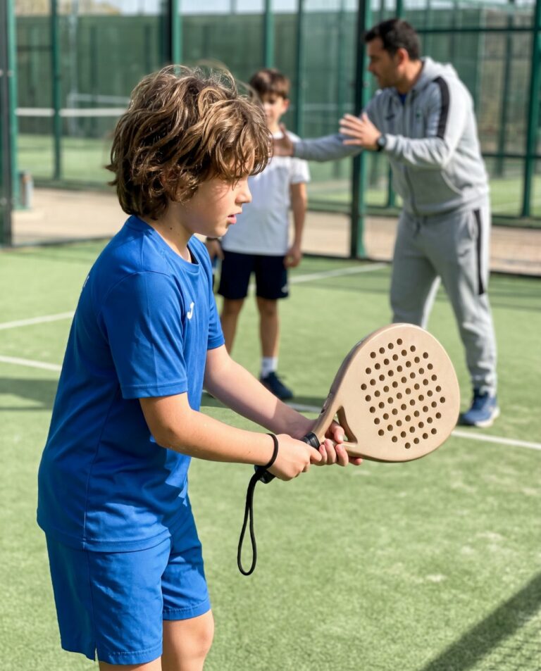 Enfant en cours de padel tenant une petite raquette