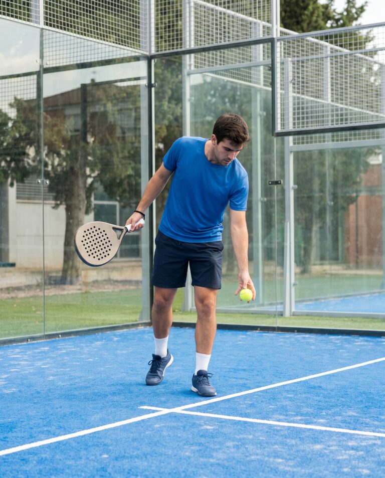 Joueur faisant rebondir la balle pour servir au padel