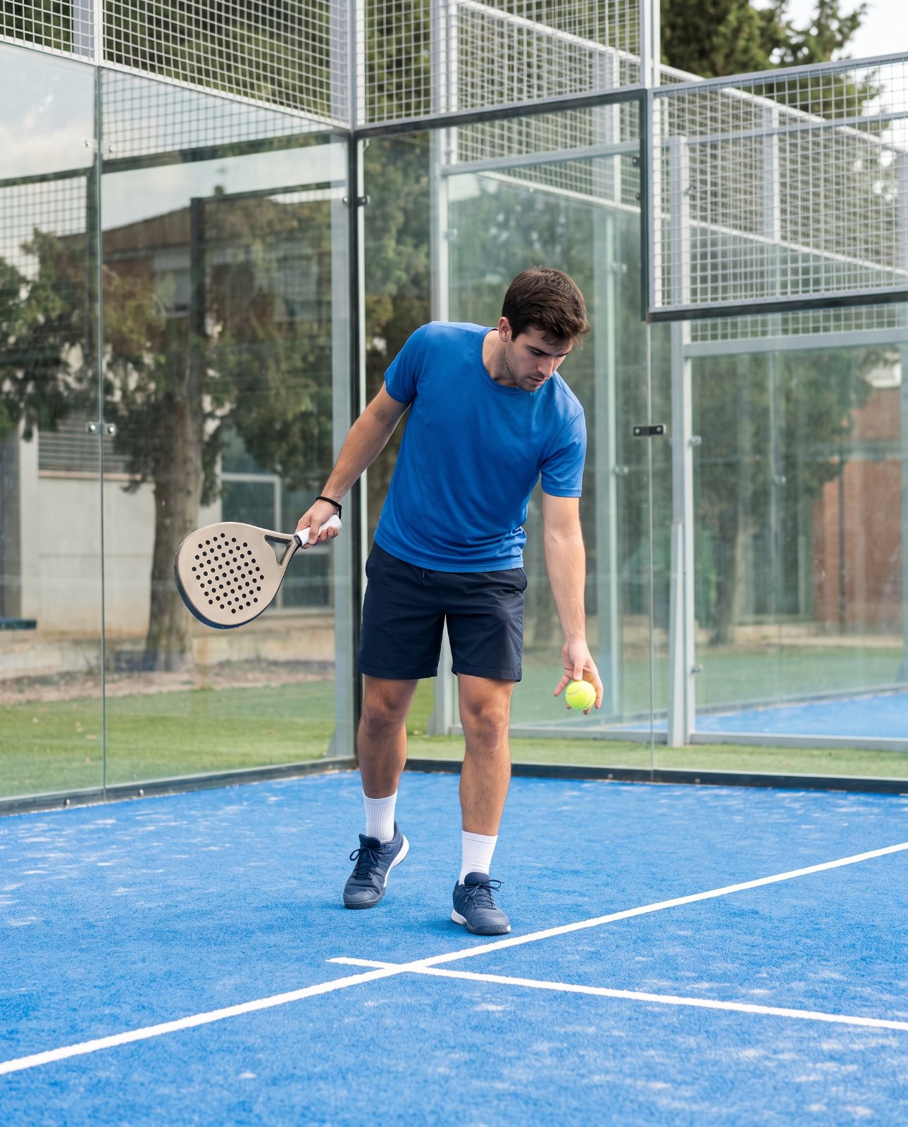 Joueur faisant rebondir la balle pour servir au padel