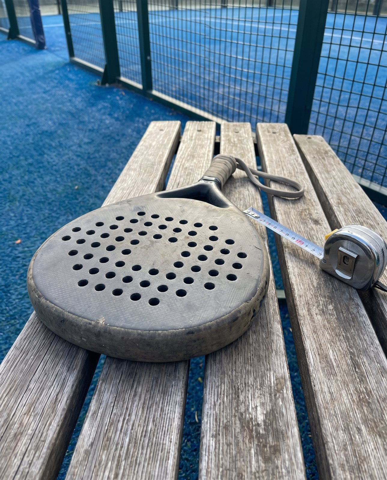 Raquette de padel posée à côté d'un mètre